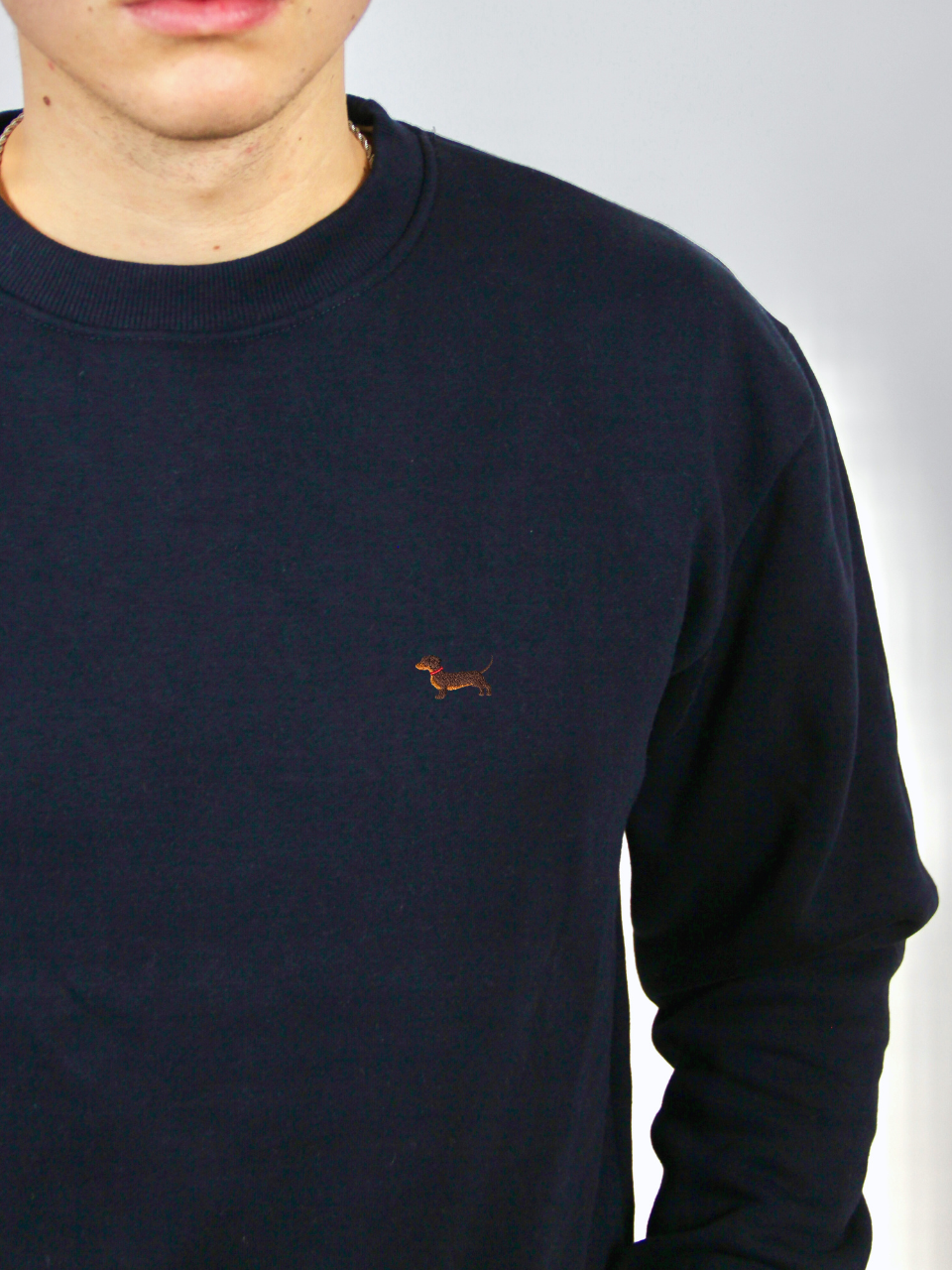 Dackel-Stickerei auf dem dunkelblauen Sweater, Nahaufnahme