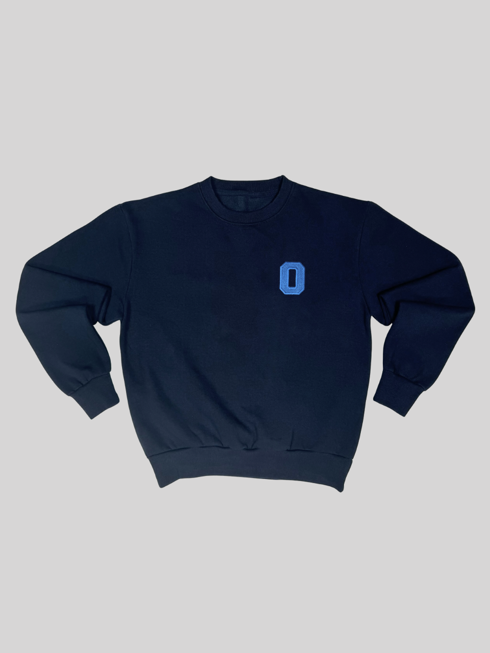 Dunkelblauer Sweater mit gestickter Initiale O, flach ausgebreitet