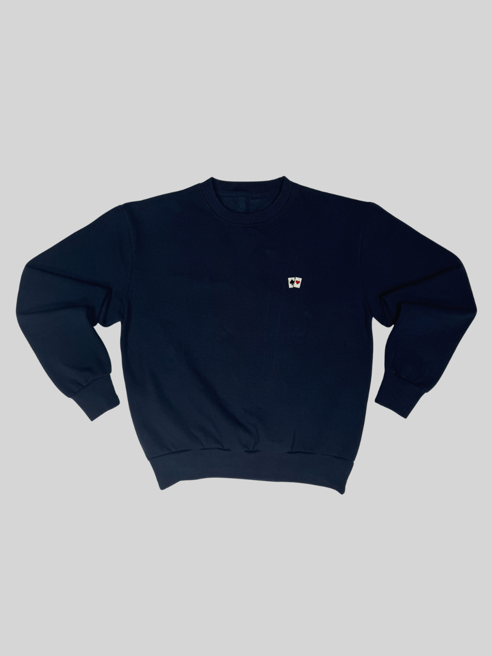 Dunkelblauer Sweater mit Spielkarten-Stickerei, flach ausgebreitet