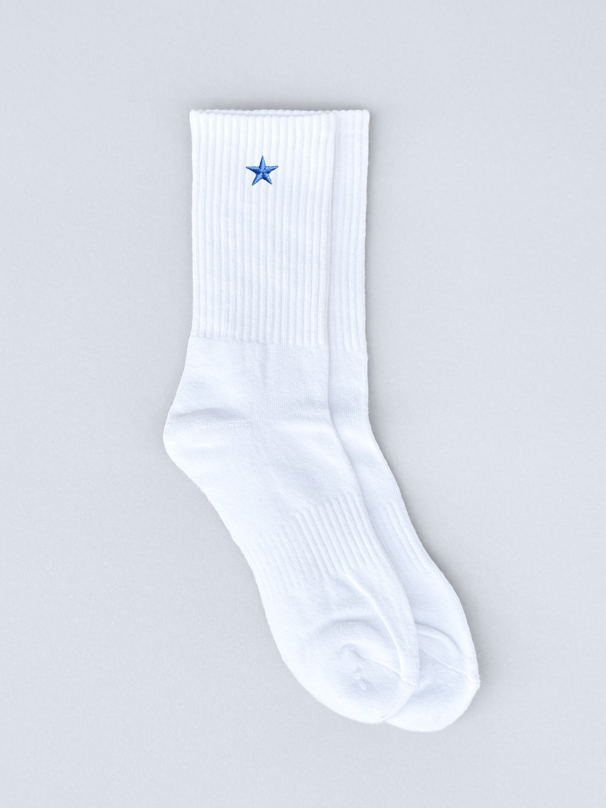 Weiße Socken mit blauer Stern-Stickerei, flach ausgebreitet