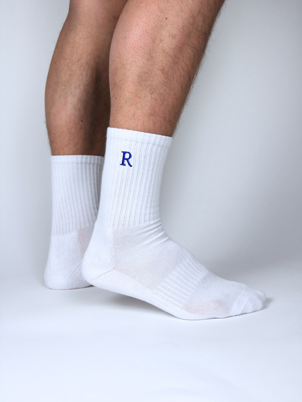 Weiße Socken mit gestickter Initiale R, getragen