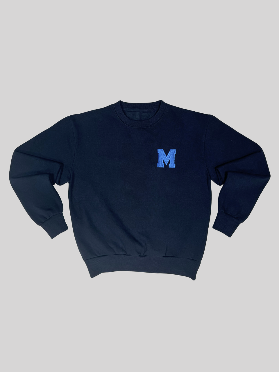 Dunkelblauer Sweater mit gestickter Initiale M, flach ausgebreitet