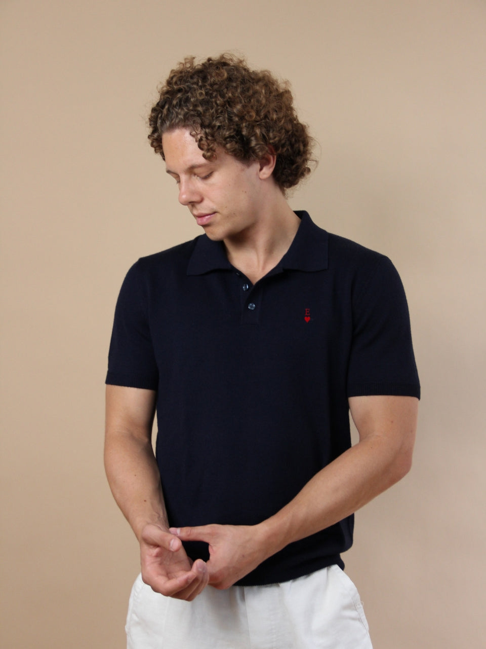 Dunkelblaues Poloshirt mit Nähmaschinen-Stickerei aus Merinowolle, seitlich am Model