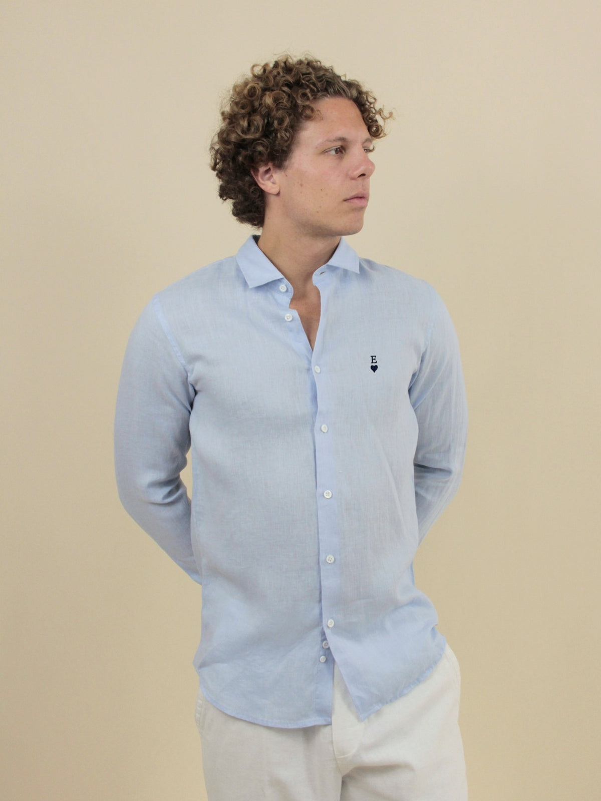 Himmelblaues Leinenhemd mit navyblauer Herz-Stickerei und Initiale E, am Model