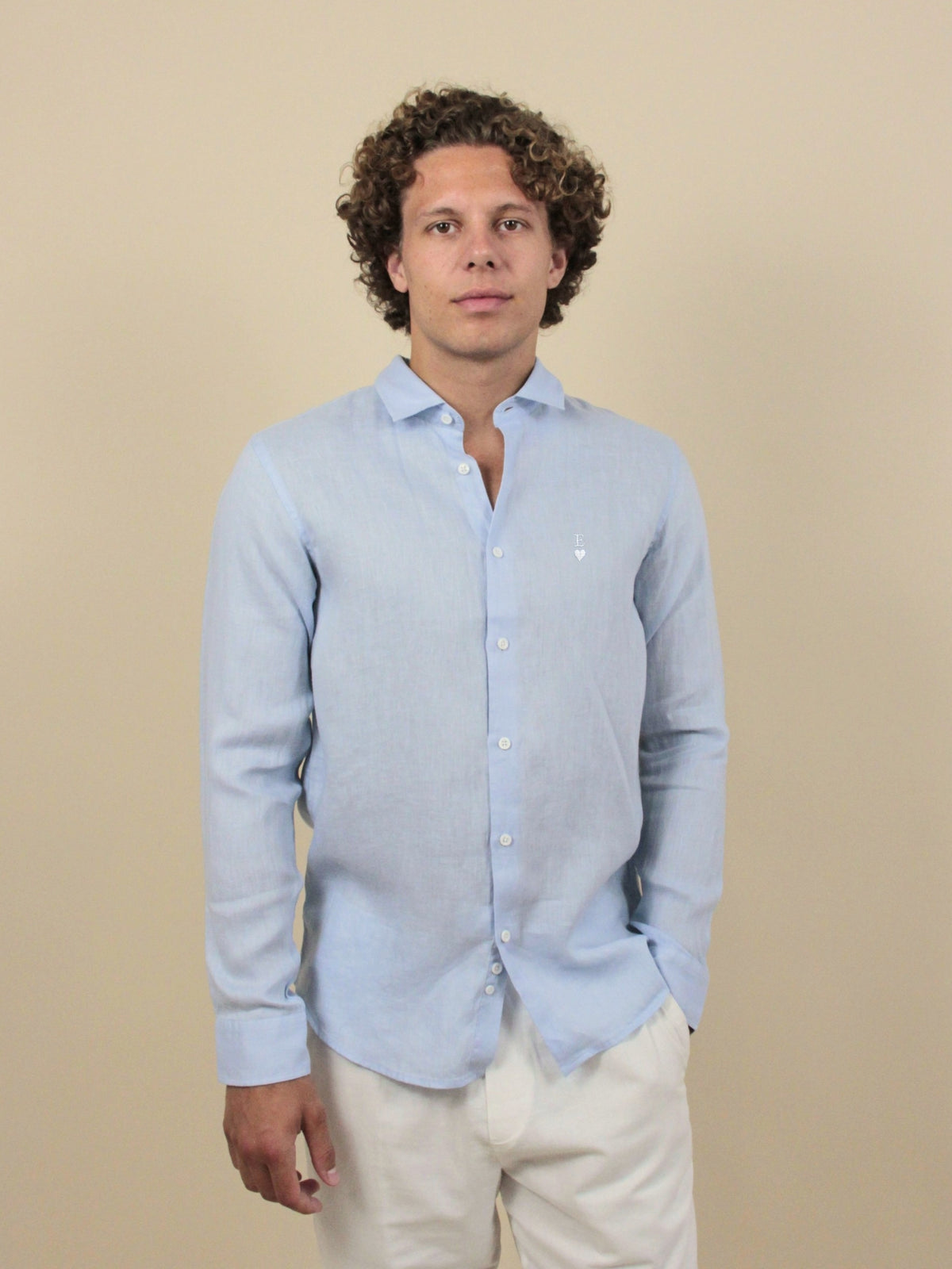 Himmelblaues Leinenhemd mit weißer Herz-Stickerei und Initiale E, am Model