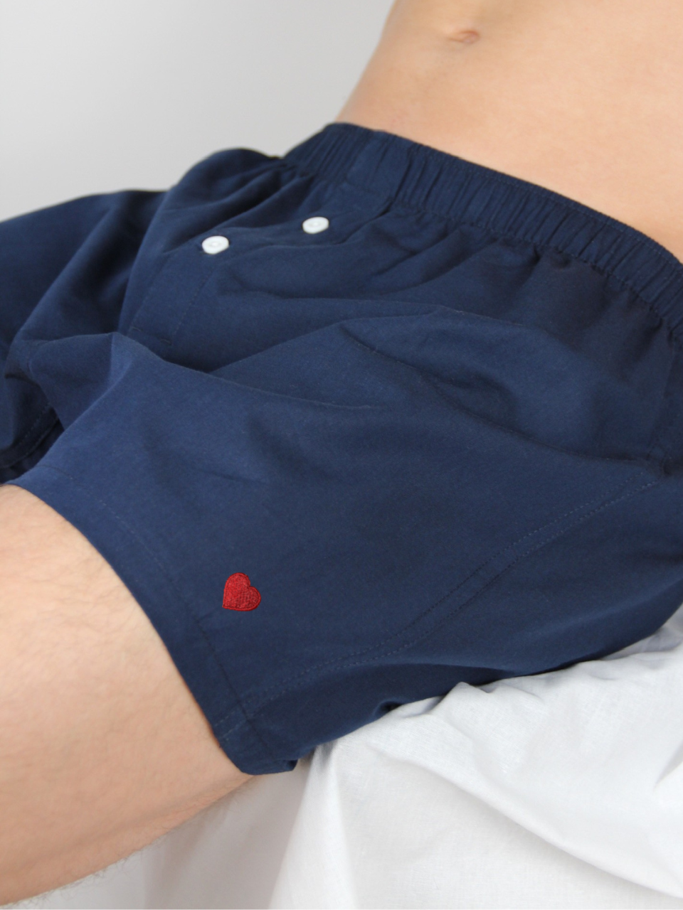 Navyblaue Boxershorts mit Herz-Stickerei, getragen im Detail
