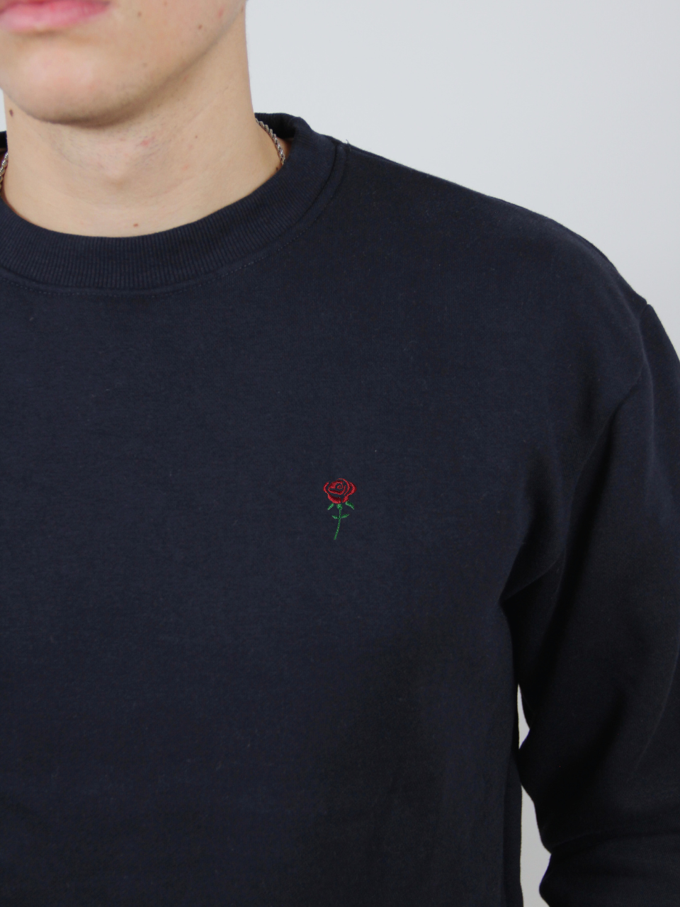 Rosen-Stickerei auf dem dunkelblauen Sweater, Nahaufnahme