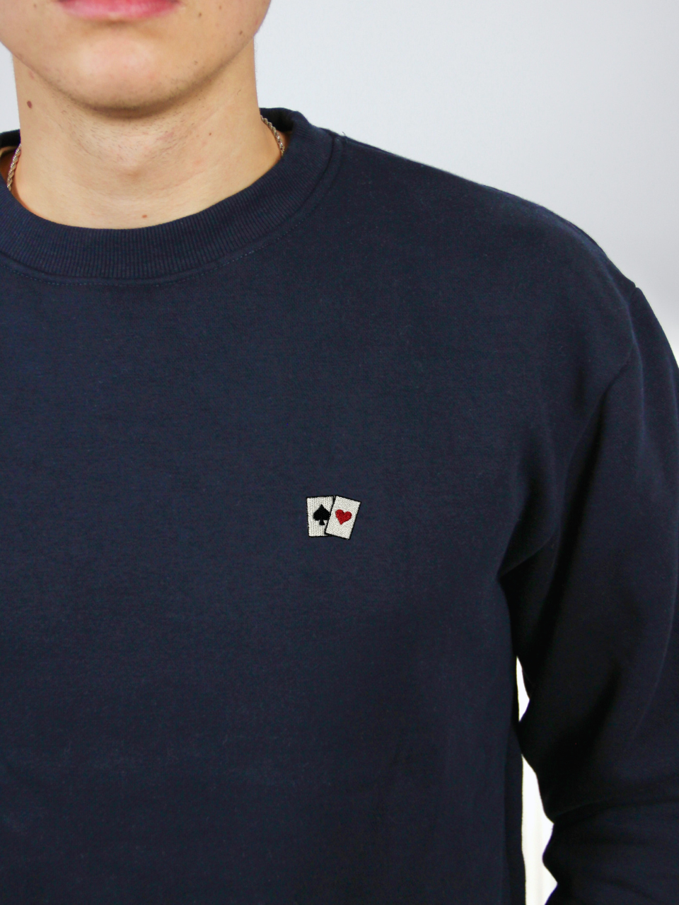 Spielkarten-Stickerei auf dem dunkelblauen Sweater, Nahaufnahme