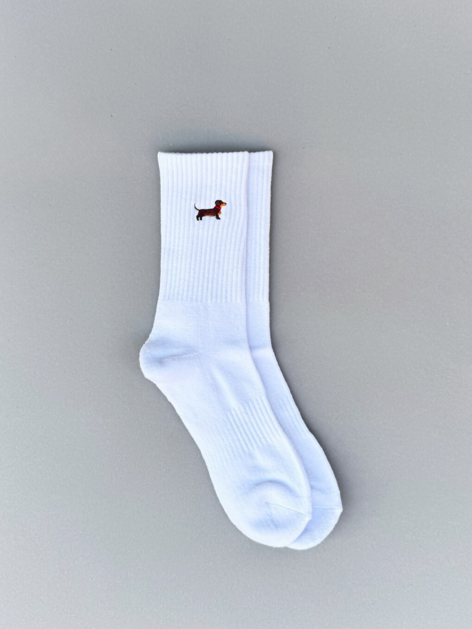 Weiße Socken mit Dackel-Stickerei, flach ausgebreitet