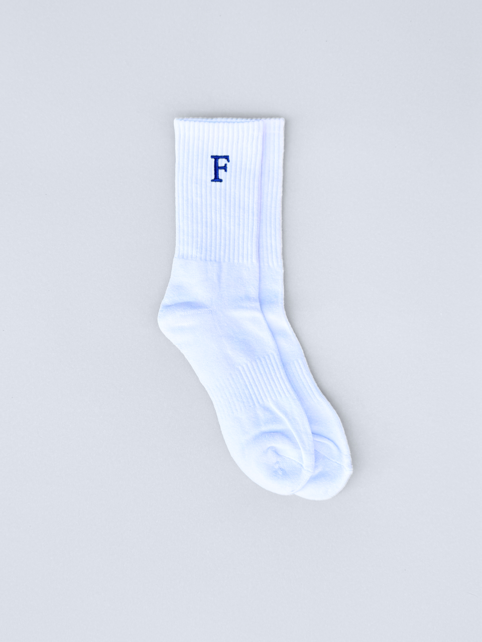 Weiße Socken mit gestickter Initiale F, flach ausgebreitet