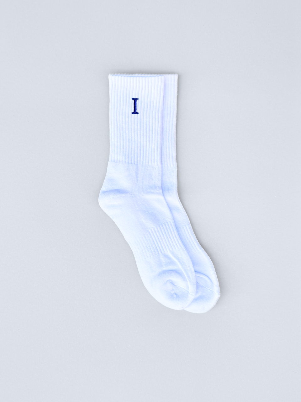 Weiße Socken mit gestickter Initiale I, flach ausgebreitet