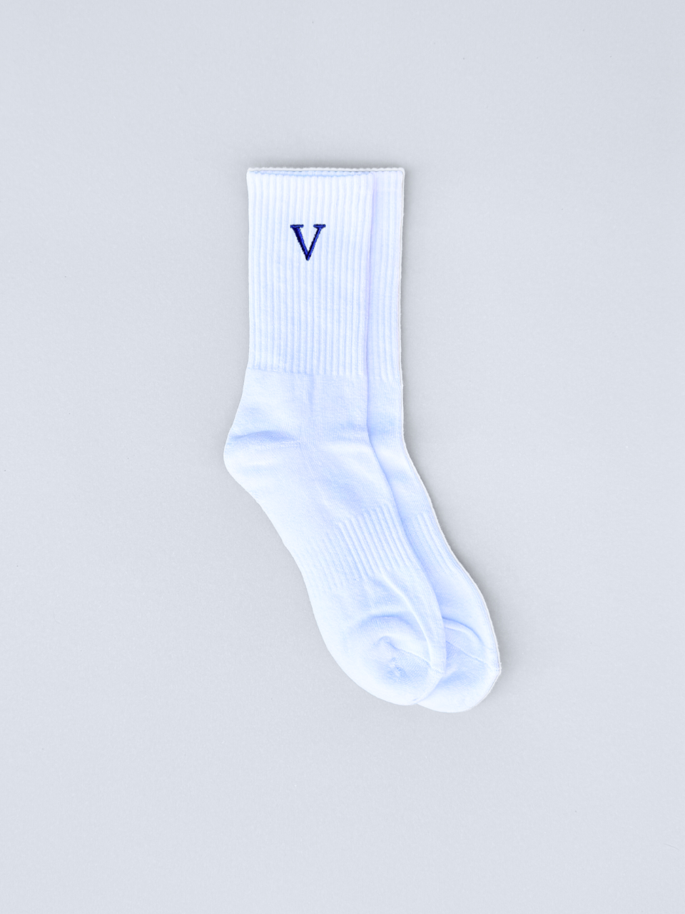 Weiße Socken mit gestickter Initiale V, flach ausgebreitet